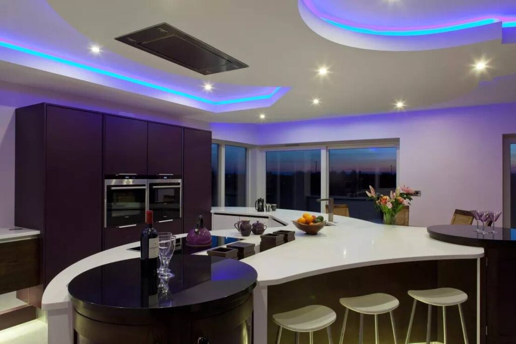 Многоуровневый белый потолок подсветкой на кухне с фиолетовым гарнитуром